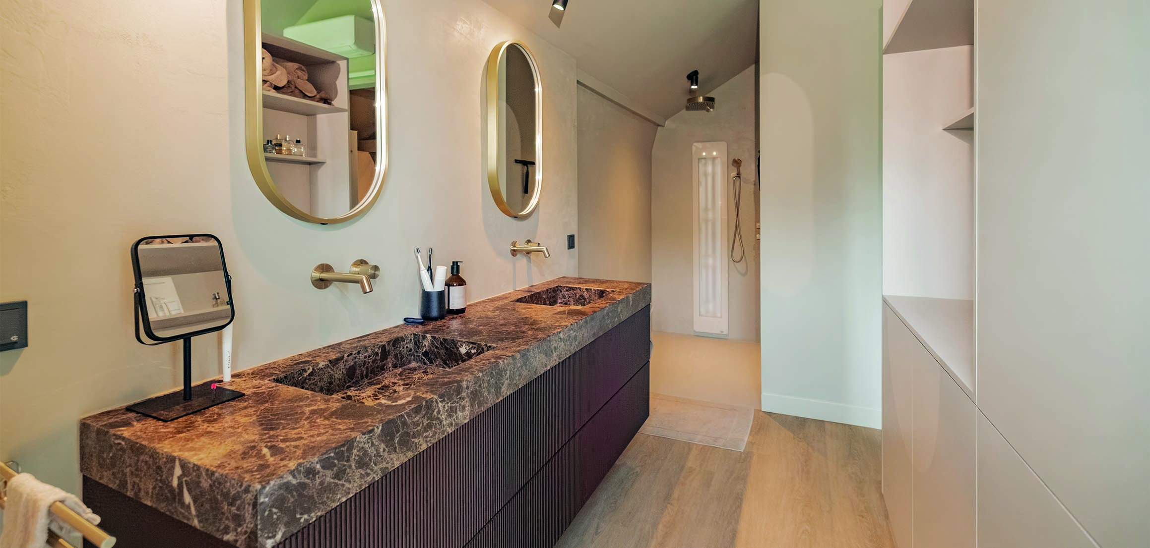 Badkamer met marmeren wastafel en ovale spiegels in Heenvliet