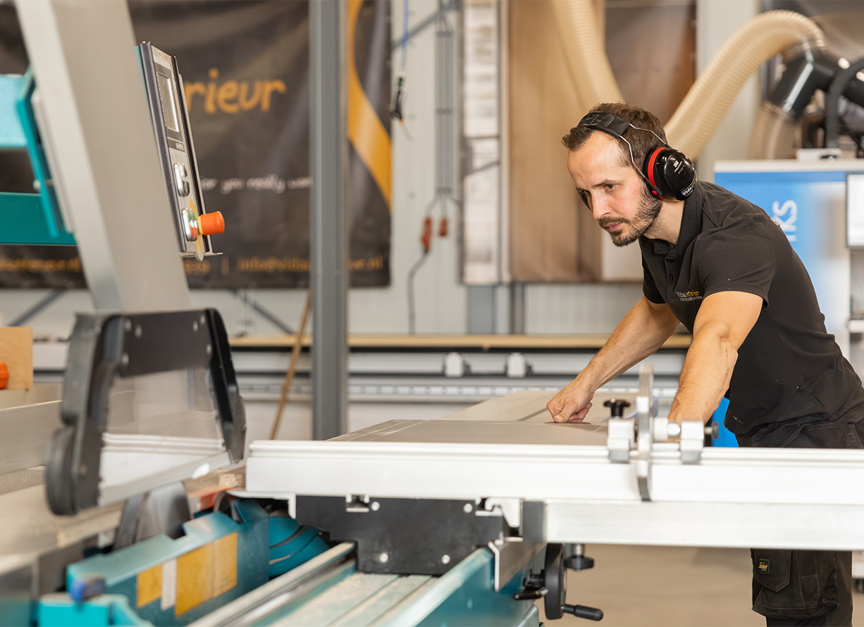Meubelmaker aan het werk bij de zaagmachine van Vida Interieur