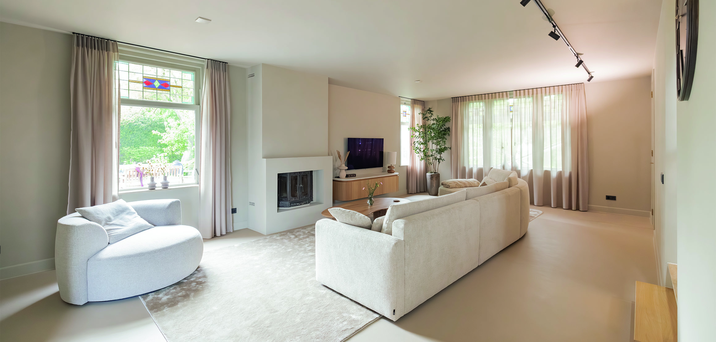 Woonkamer met open haard en witte banken in Heenvliet