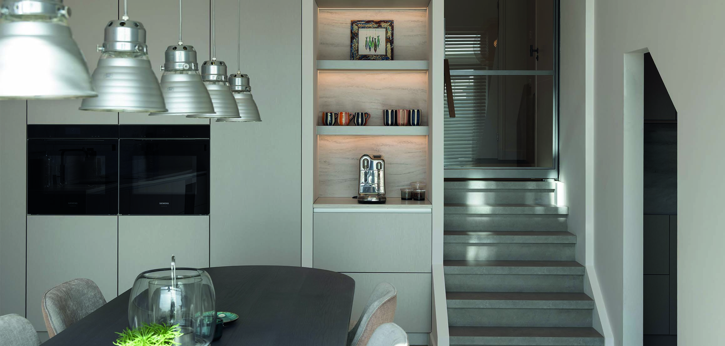Eettafel bij maatwerk wand met verlichte vakken in Hellevoetsluis