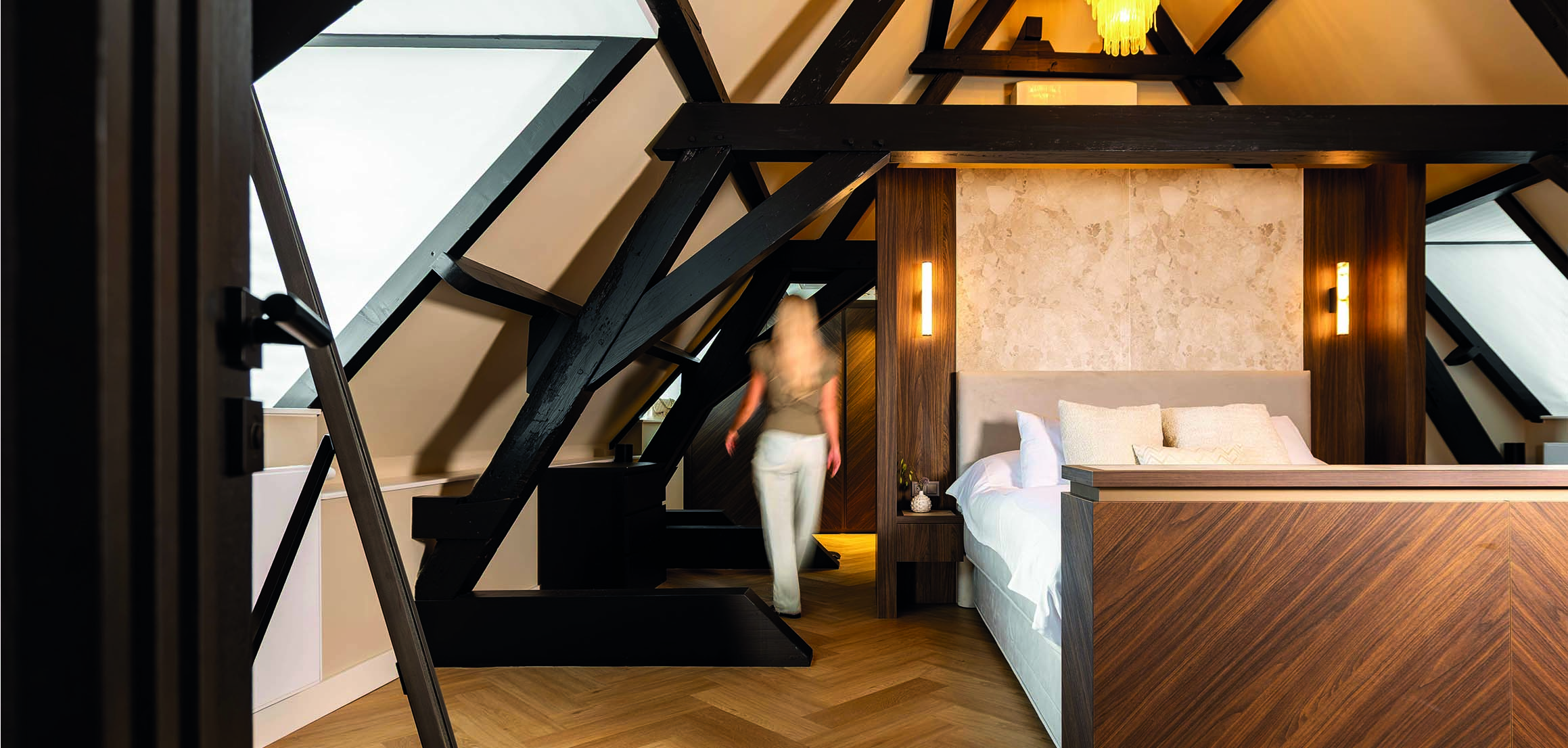 Master bedroom onder donkere spanten in Warmond
