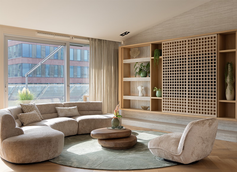 Woonkamer met ronde bank en maatwerk kastenwand in de Markthal in Rotterdam